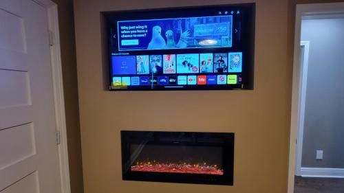 a flat screen tv on a wall with a fireplace at Home Stay in Atlanta