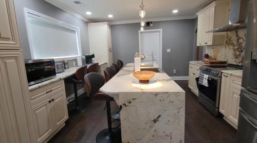 a large kitchen with a marble counter top and chairs at Home Stay in Atlanta
