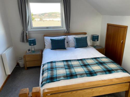 a bedroom with a large bed with a window at Hillside View, Inverness in Inverness