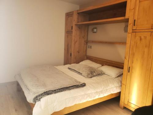 - une chambre avec des lits superposés en bois et des draps blancs dans l'établissement Les Chalets Des Rennes - Appartement moderne 2P4 - Les Chalets Des Rennes MAE-6551, à Vars
