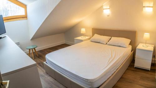 une chambre avec un lit blanc avec deux tables de nuit dans l'établissement Résidence Le Balcon Des Airelles - Bel appartement au coeur des Orres 1800 MAE-6591, aux Orres
