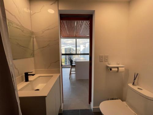 baño con lavabo y aseo y ventana en Luxury apartment in San José, en San José
