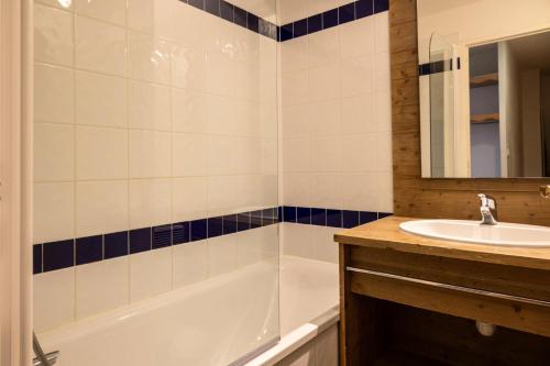 une salle de bain avec une baignoire blanche et un lavabo dans l'établissement Résidence Le Parc Des Airelles - Appartement agréable au pied des pistes MAE-6611, aux Orres