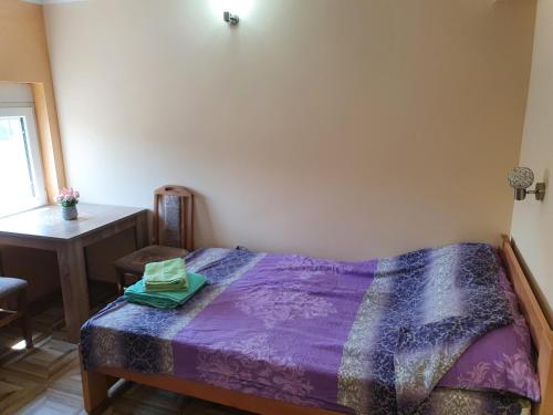 a bedroom with a bed with a purple comforter at Small cute doublebed room A4 in Pančevo in Pančevo
