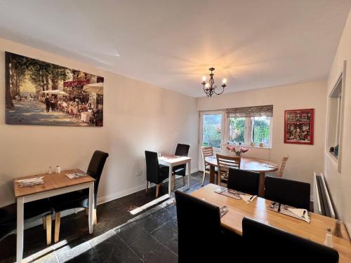 uma sala de jantar com mesas e cadeiras e um quadro na parede em Ashfield Bed & Breakfast em Belfast