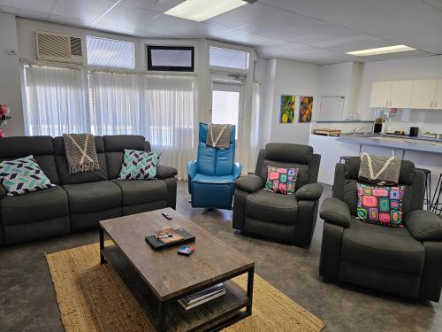 a living room with couches and chairs and a table at Aart Apartments in Port Lincoln