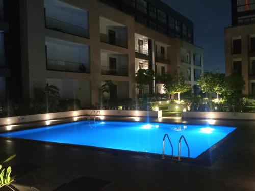 een zwembad voor een gebouw 's nachts bij Luxury Two Bedroom at Embassy Gardens by Morninglife Luxury Apartments in Accra