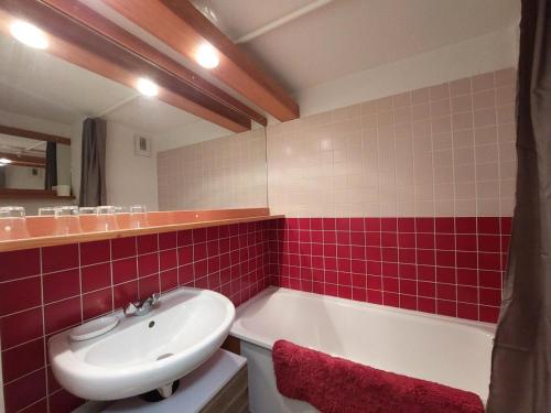 uma casa de banho com um lavatório e uma banheira em Résidence Aiguille Grive Bat Iii - 3 Pièces pour 6 Personnes 441 em Arc 1800
