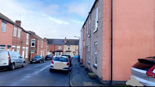 a street with cars parked on the side of a building at Herbert - Duplex Relocations in Mexborough