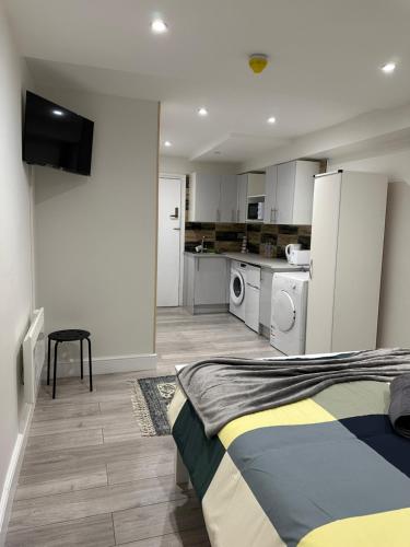 um pequeno quarto com uma cama e uma cozinha em Guest&rest Ealing 1 em Ealing