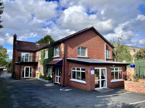 a red brick house with a parking lot at Ashfield Bed & Breakfast in Belfast