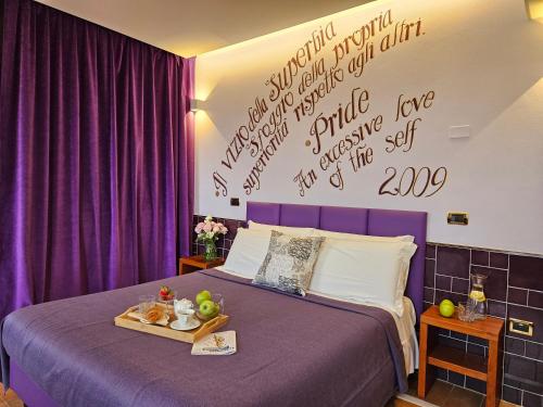a bedroom with a bed with a tray of fruit on it at B&B 7 Vizi in Colà di Lazise
