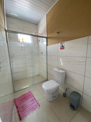 a bathroom with a toilet and a glass shower at Rio Formoso Residencial in Bonito