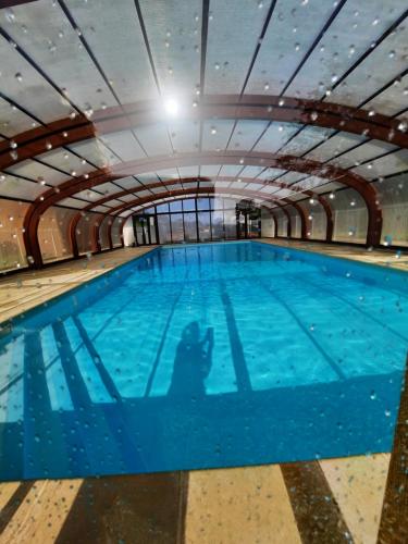 una gran piscina cubierta de agua azul en Normandie chalet N70 piscine lac golf en Saint-Manvieu-Bocage