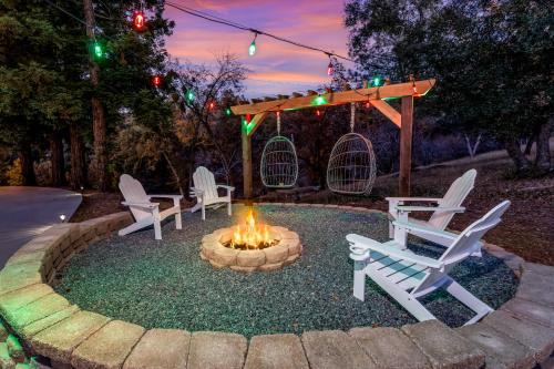 a fire pit in a yard with white chairs at TWO homes with Stunning Views King Bed, Level 2 Electric Vehicle Smart Station, Hot Tub, Games and Fire pit, Perfect for Multi-Family Getaways in Coarsegold