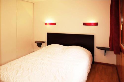 - une chambre avec un lit blanc et deux lumières sur le mur dans l'établissement Residence La Combe D Or - Appartement en résidence de standing MAE-6334, aux Orres