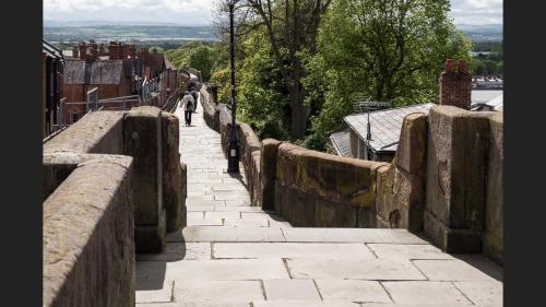 a person walking down a stone bridge at The Highfield Chester. in Chester