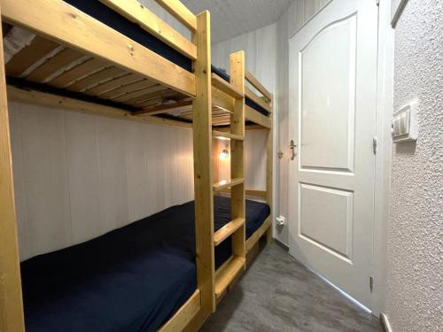 a bunk bed room with two bunk beds and a door at Résidence Grande Masse - Studio pour 3 Personnes 911 in Les Menuires