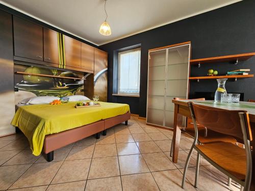 a bedroom with a yellow bed and a table at B&B 7 Vizi in Colà di Lazise