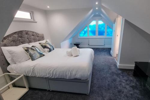 a bedroom with a large bed with a large window at Northbourne House in Longham