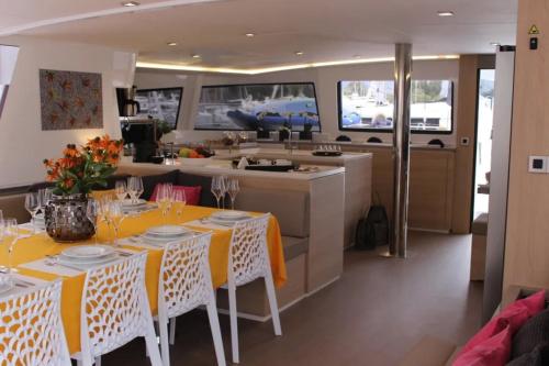 a kitchen and dining room with tables and a kitchen at Catamaran Bali 5.4 in Athens