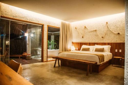 a bedroom with a bed and a sliding glass door at POUSADA ZAYA in São Miguel dos Milagres