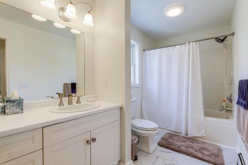a white bathroom with a sink and a toilet at Mystic Retreat with Patio and Grill Walk to River! in Mystic