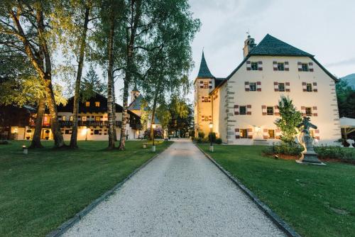 eine Auffahrt, die zu einem großen weißen Gebäude führt in der Unterkunft Schloss Prielau Hotel & Restaurants in Zell am See