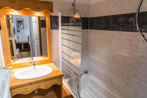 une salle de bain avec un lavabo, un miroir et une baignoire dans l'établissement Résidence Les Hauts De Preclaux - 2 pièces au coeur des Orres 1800 MAE-8361, aux Orres