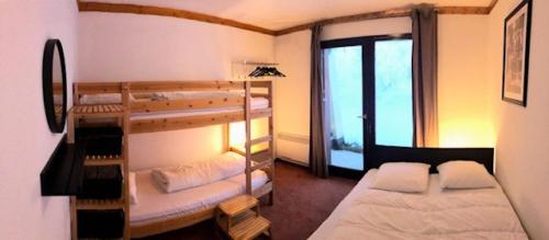 een kamer met 2 stapelbedden en een raam bij Chalets Du Thabor - 3 Pièces pour 8 Personnes 291 in Modane