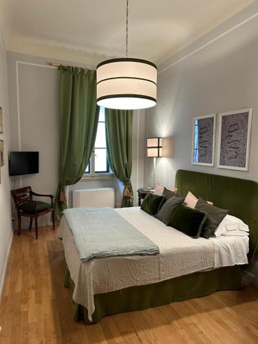 a bedroom with a large bed with a green headboard at Residenza dei Pucci in Florence