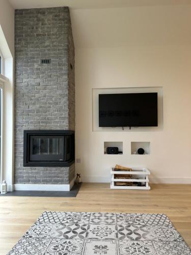 a living room with a fireplace and a flat screen tv at Gili Taigh in Fort William