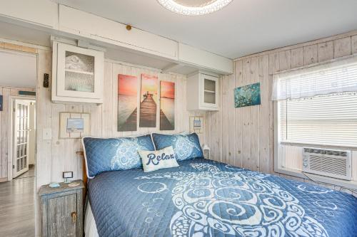 a bedroom with a blue bed and wooden walls at 1 Mi to Surfside Beach BBQ-Ready Home in Freeport in Freeport