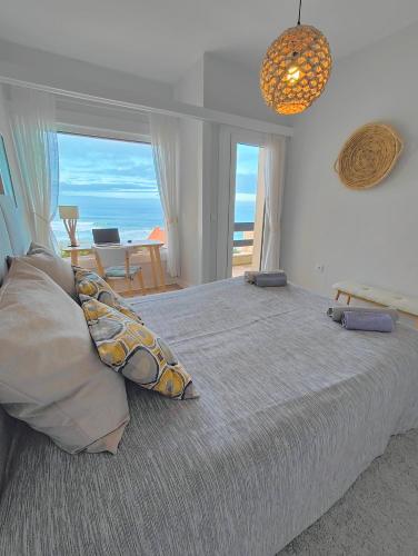 a bedroom with a large bed with a view of the ocean at Santa Cruz Ocean Apartment - I in Santa Cruz