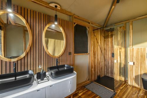 a bathroom with two mirrors and a sink at Anantya Serengeti in Serengeti