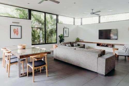 a living room with a couch and a table at Byron Luxury Beach Houses in Byron Bay