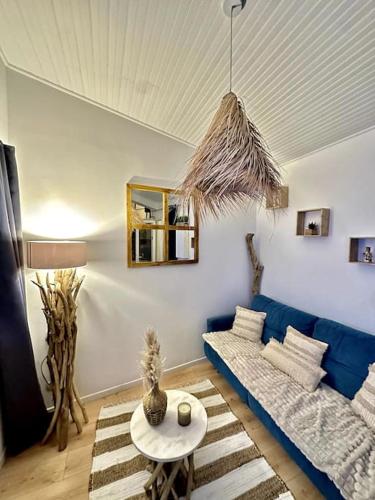 un salon avec un canapé bleu et une table dans l'établissement La Tanière du Bois Flotté, à Nice