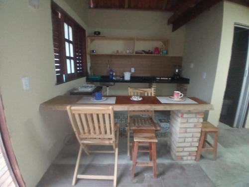 a kitchen with a table and chairs in a room at Chales Da Mata in Fortim
