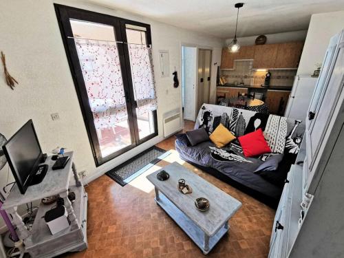 un salon avec un canapé et une fenêtre dans l'établissement Résidence MAISONS DES SABLES 4 - 2 Pièces pour 4 Personnes 04, à Port-Leucate