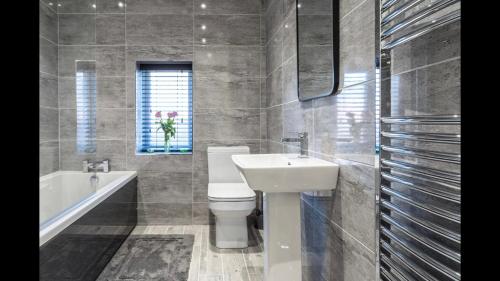 a bathroom with a sink and a toilet and a tub at The Highfield Chester. in Chester