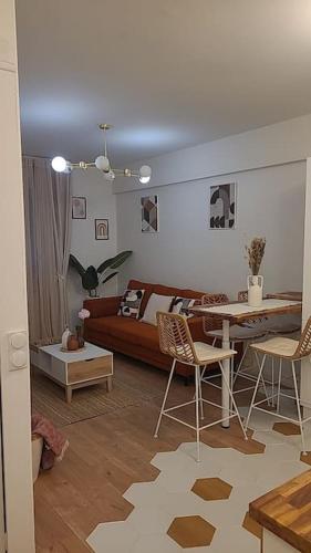 un salon avec un canapé, une table et des chaises dans l'établissement Appartement au cœur de la cité d'Angoulême, à Angoulême