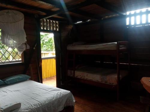 a bedroom with two bunk beds and a window at Hostal TÉ de Menta in Muisne