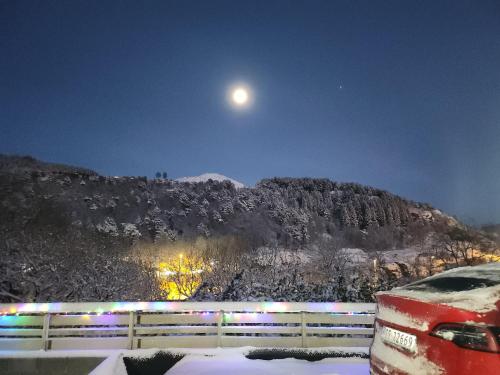 uma montanha coberta de neve com a lua no céu em Fjordclaw SNM- adjoining the Bergen city & Nature em Bergen