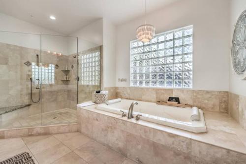 ein großes Bad mit einer Badewanne und einer Dusche in der Unterkunft HotTub, Pool, Waterfall, RV parking 5BR Lux Home in Las Vegas
