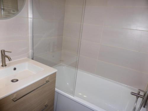 y baño blanco con lavabo y ducha. en Résidence Combettes - Studio pour 4 Personnes 071, en Les Contamines-Montjoie