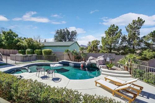 a swimming pool with two lounge chairs and a pool at 8000sf 7BR Villa Casita Pool Spa Gym & Games in Las Vegas