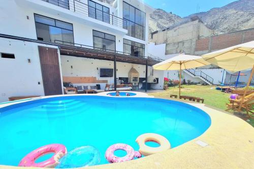 una gran piscina con dos tubos inflables frente a un edificio en Casa de campo Pink21 en Lima