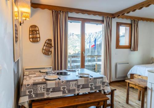 Cette chambre comprend une table, un lit et une fenêtre. dans l'établissement Résidence Les Hauts De Preclaux - Charmant 2 pièces au coeur des Orres 1800 MAE-9131, aux Orres