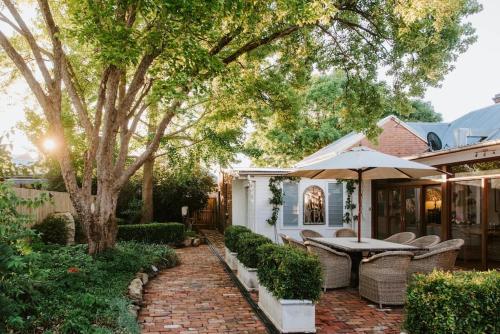 a patio with a table and chairs under a tree at Cawarra on the Park - Historic Mudgee Grandeur in Mudgee