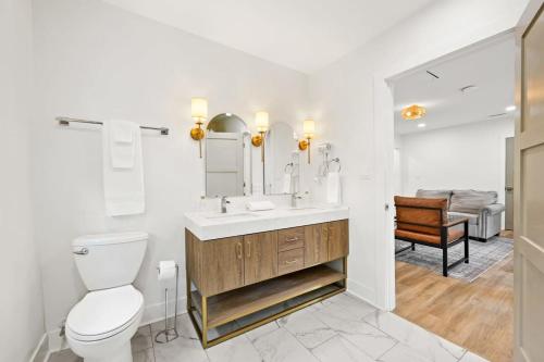 a bathroom with a toilet and a sink with a mirror at Bungalow on Main - Near Ark in Williamstown